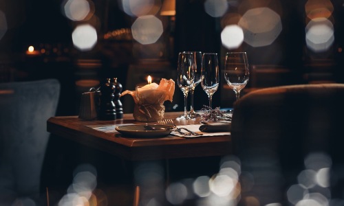 wine glasses and a candle in a warm lit restaurant